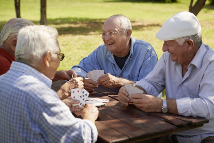 A group of friends playing cards outdoors.