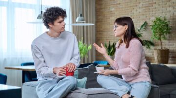 Middle-aged mother talking to her 18-year-old son at home