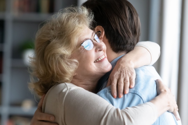 A mother hugging her adult son.