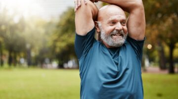 A man stretching in a park.