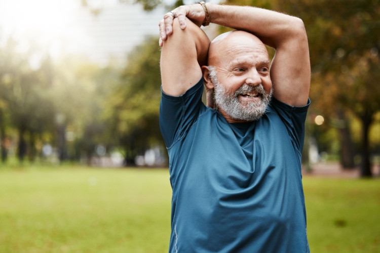 A man stretching in a park.