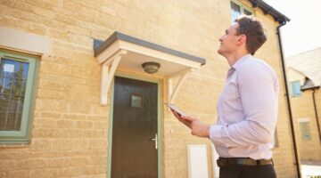 An estate agent outside of a property.