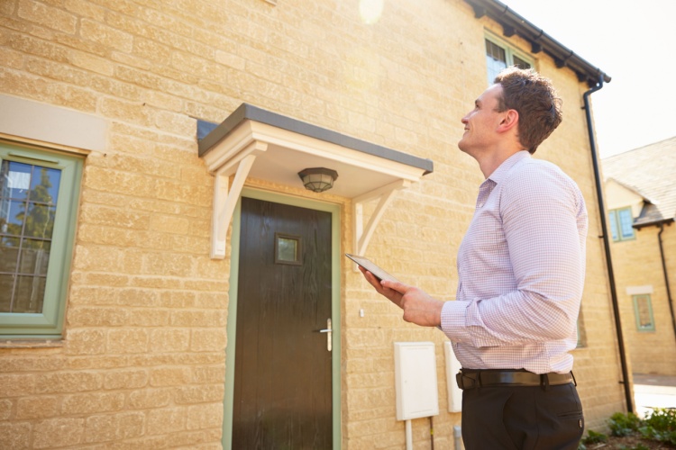 An estate agent outside of a property.