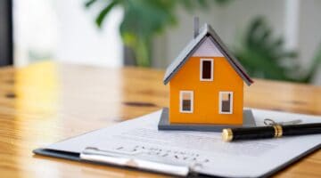 A model of a house sitting on some paperwork.