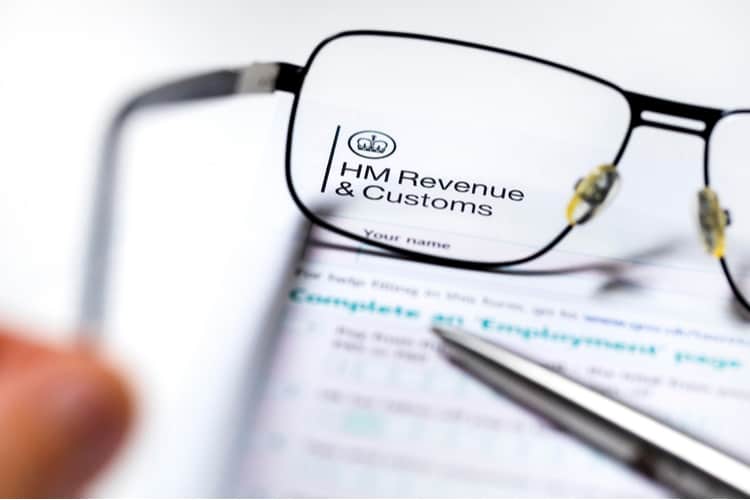Someone holding glasses up to a HMRC letter.