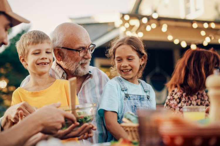 A grandfather laughing with his grandchildren.