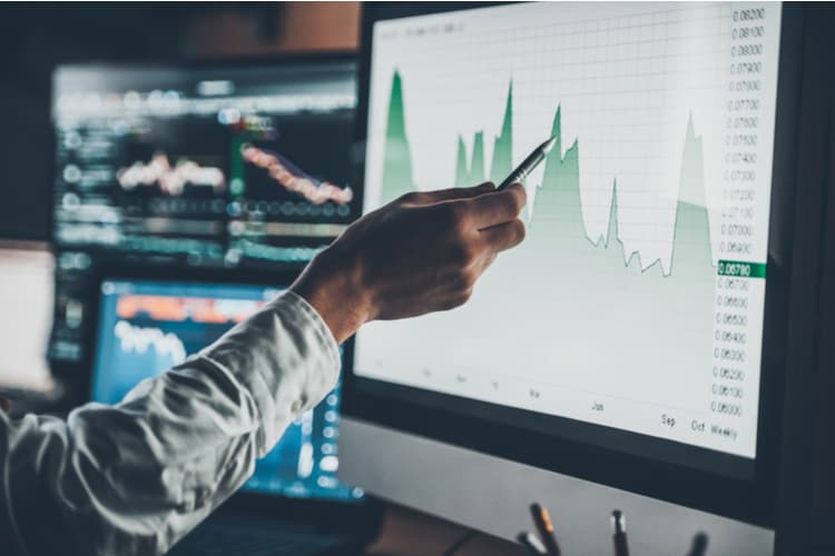 A man pointing to a screen showing data on a chart