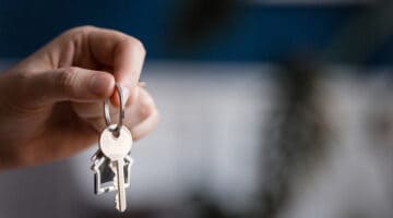 A hand holding up some house keys