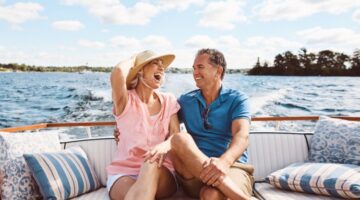 A couple in their 50s laughing on a boat together.