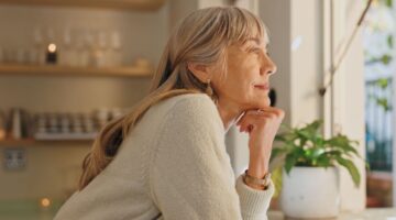 A woman looking out of the window at home.