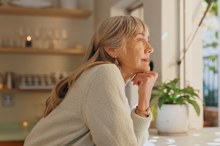 A woman looking out of the window at home.