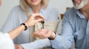 A couple collecting house keys from an estate agent.