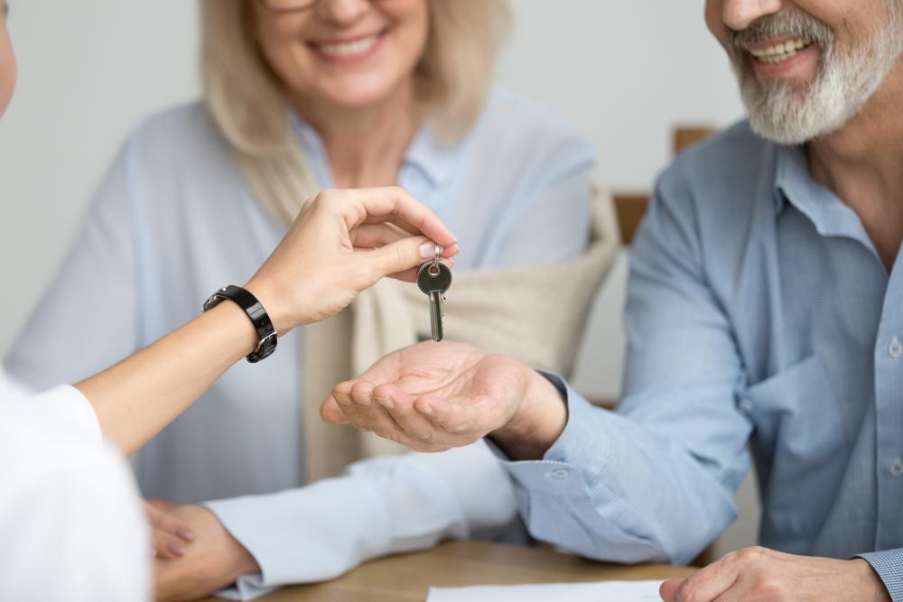A couple collecting house keys from an estate agent.