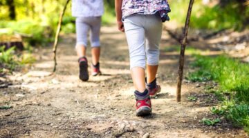 Two children hiking in a forest.