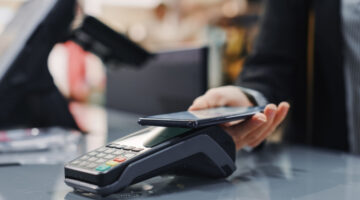 A woman paying for items in a shop.